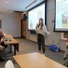 Annalise Cabra holds microphone and Emily Jerris looks on as they present about CU Women of Quantum