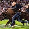 Wes Weber and his teammates run down the football field trailing Ralphie, the live buffalo mascot.