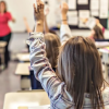 child raising hand in class