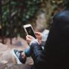 Person sitting on steps outside holding a phone